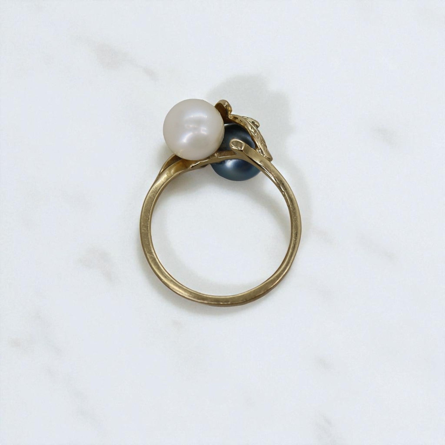 Vintage 14k gold ring with black and white pearl leaf design, showcasing intricate craftsmanship and elegant detailing.