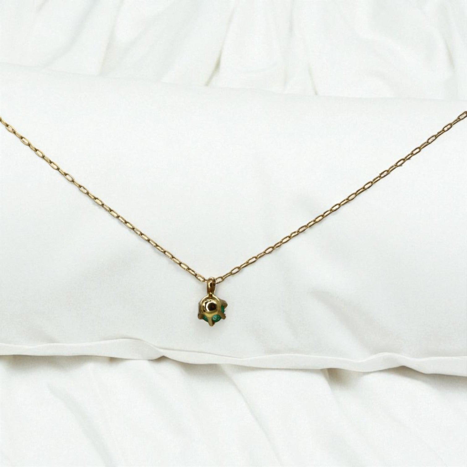 14k gold emerald pendant necklace from the 1990s featuring a vibrant green emerald gemstone on a delicate gold chain.