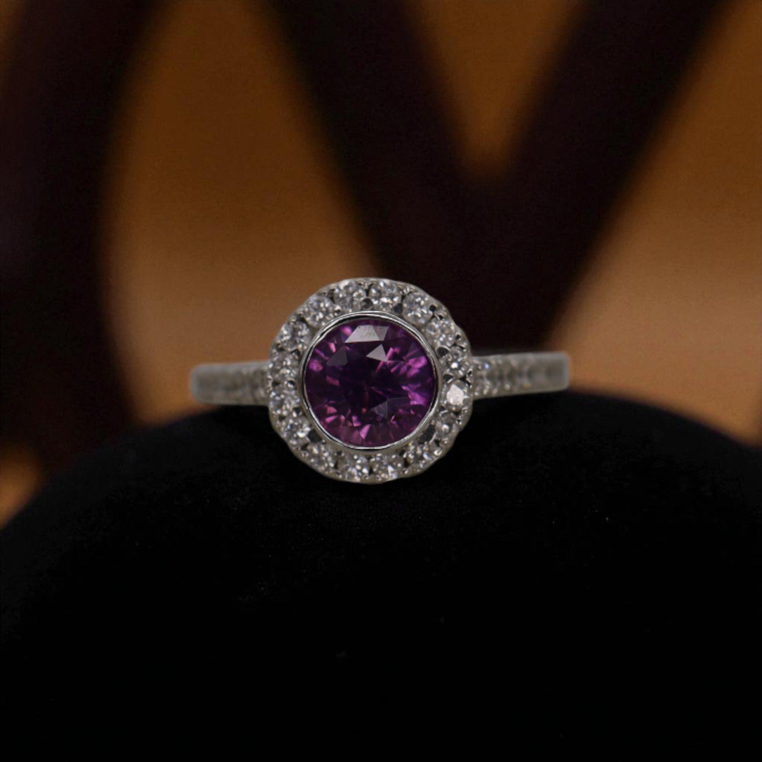Purple sapphire halo engagement ring featuring a central purple sapphire stone surrounded by a sparkling halo setting.