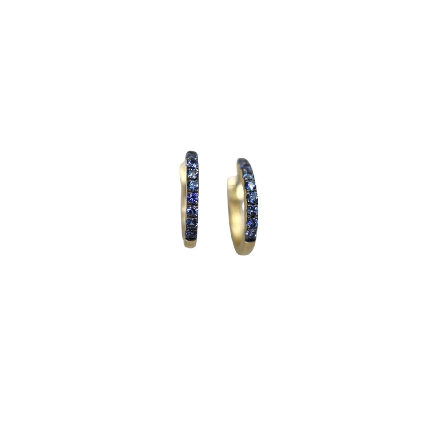 14k yellow gold sapphire huggie earrings by Dilamani featuring small, sparkling blue sapphires in a close-fitting hoop design.