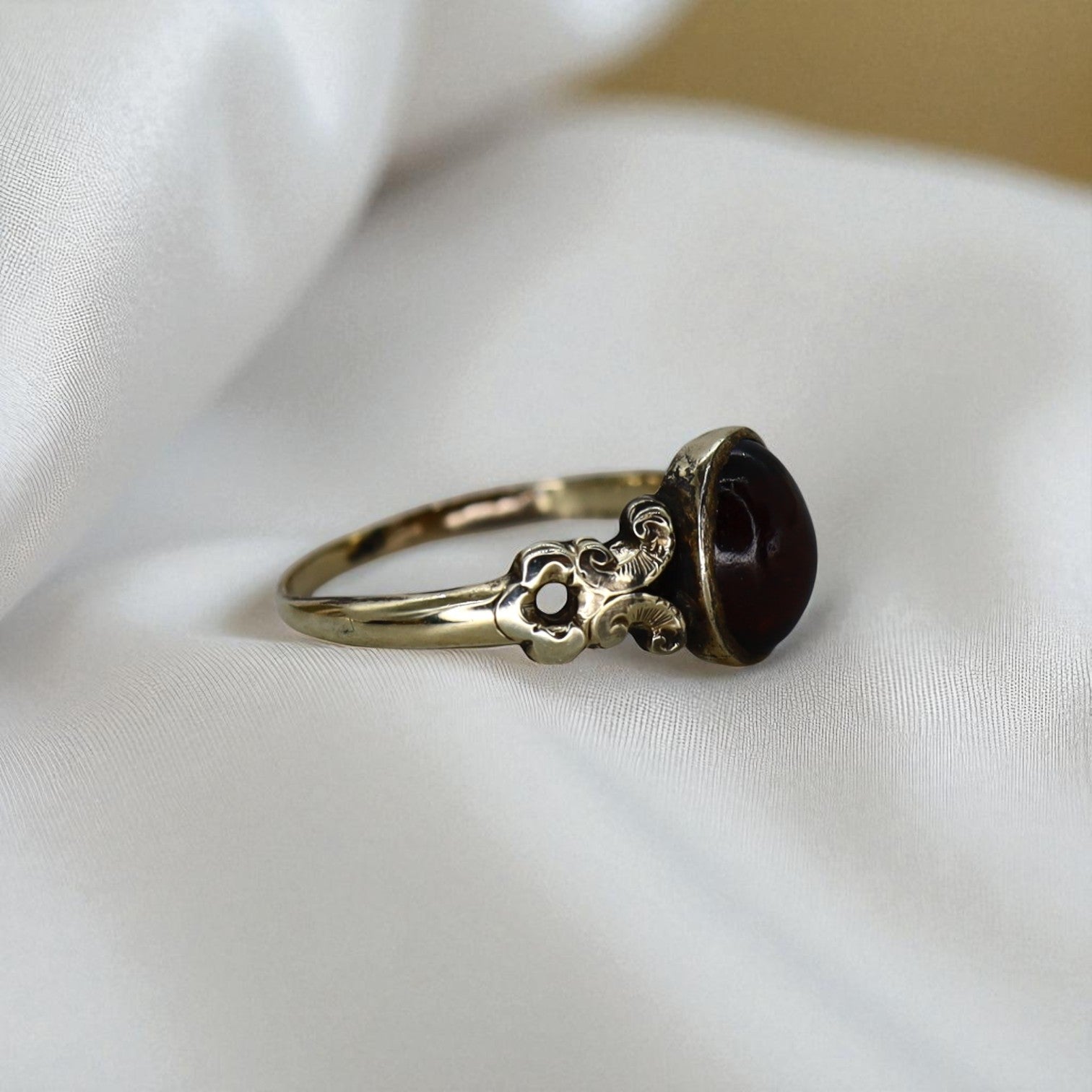 Victorian Garnet Ring featuring a deep red garnet gemstone set in intricate vintage-style metalwork.