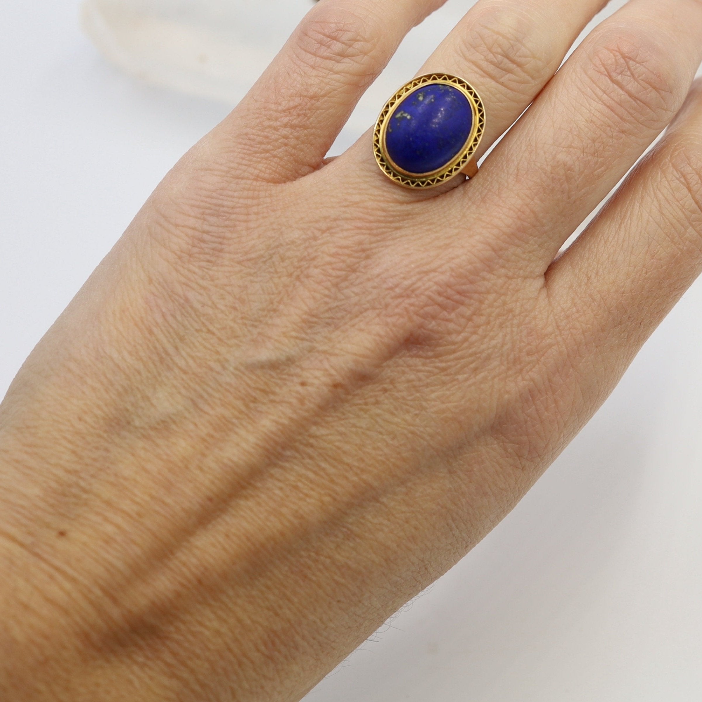 Antique lapis mizpah ring with Victorian-style design, featuring a central blue lapis stone set in a detailed metal band.