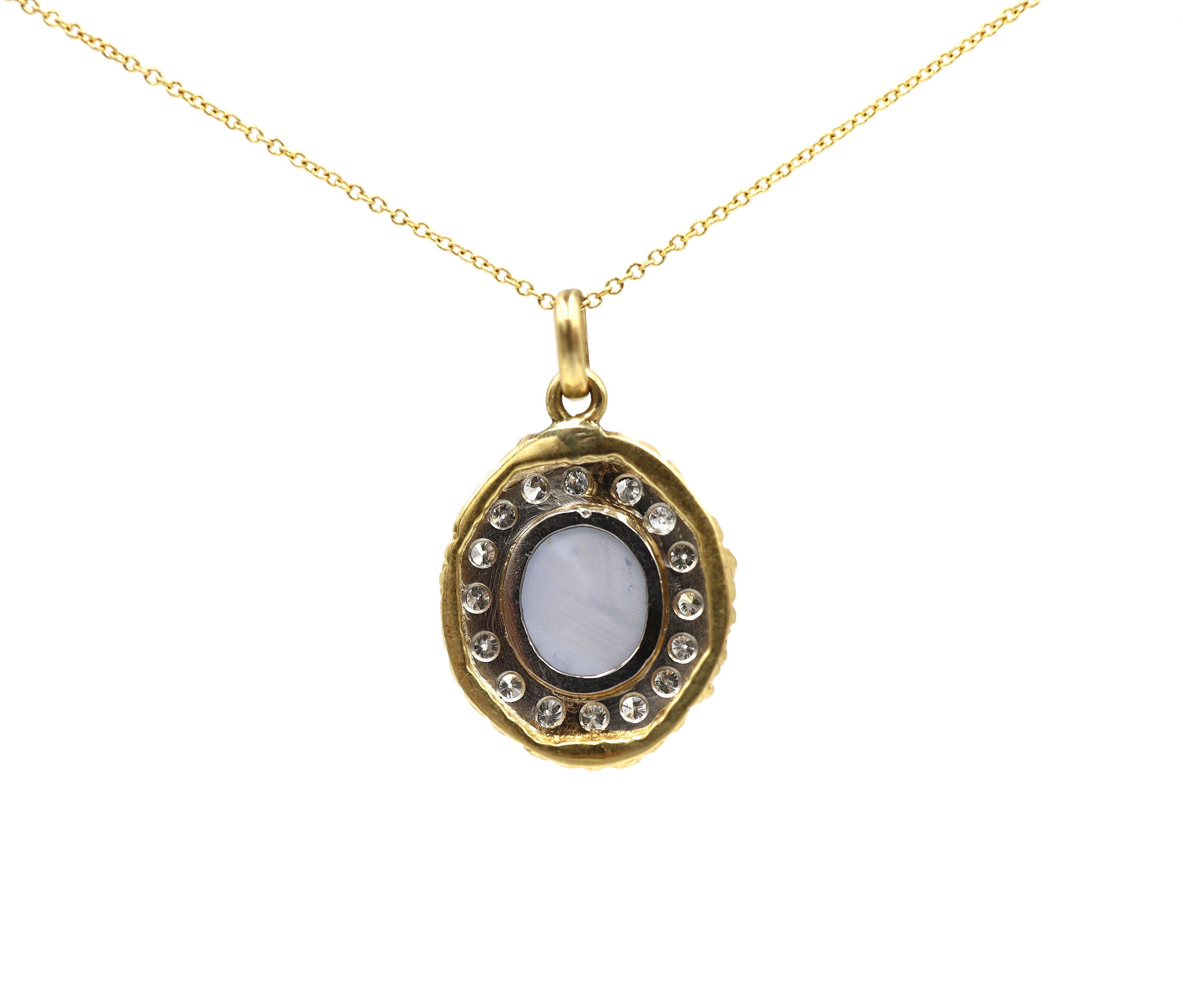 Star sapphire and diamond halo pendant from The Vintage Vault featuring a central star sapphire gemstone surrounded by a diamond halo.