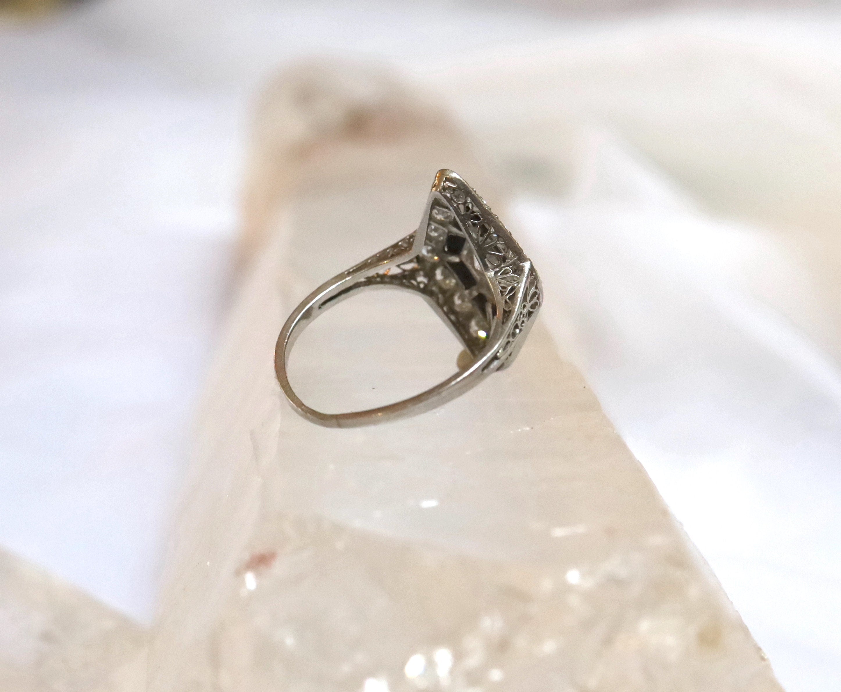 Platinum Art Deco engagement ring with black onyx gemstone, featuring vintage design details by The Vintage Vault.