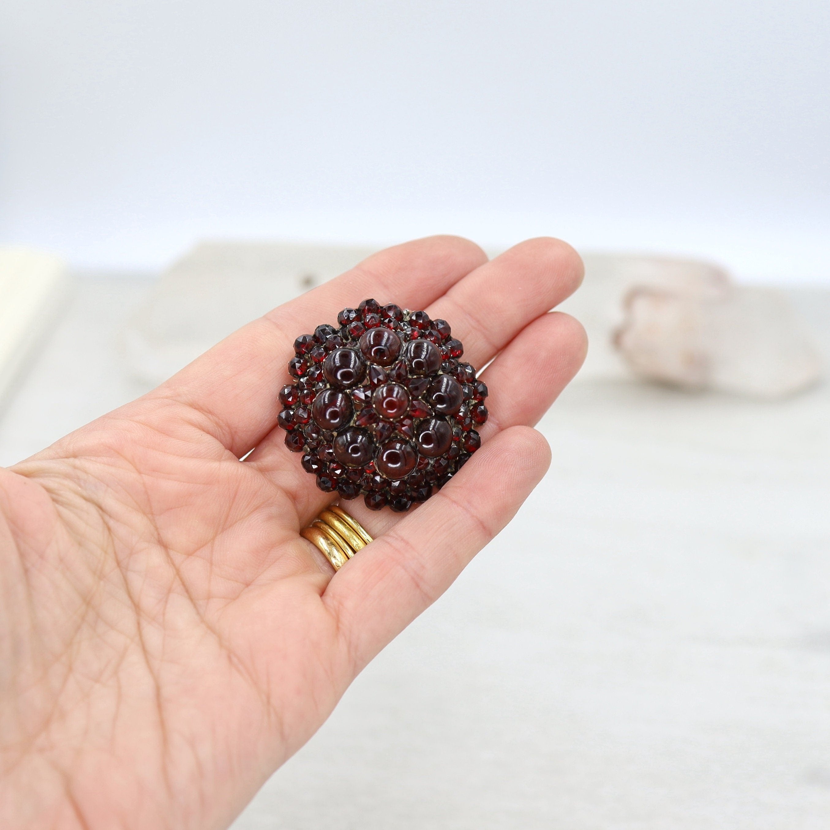 Authentic early-Victorian Bohemian garnet pendant brooch featuring intricate metalwork and deep red garnet stones.