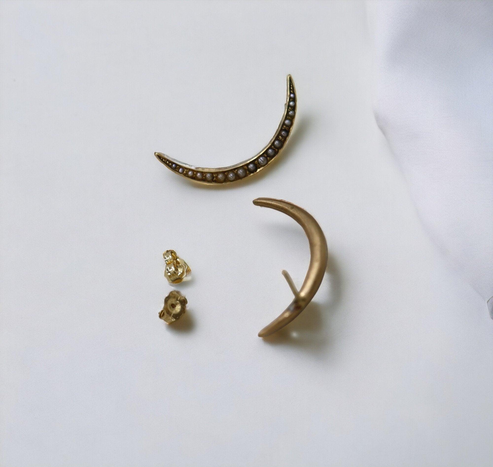 Victorian crescent moon pearl stud earrings in 10k yellow gold with a vintage design, featuring white pearls and gold settings.