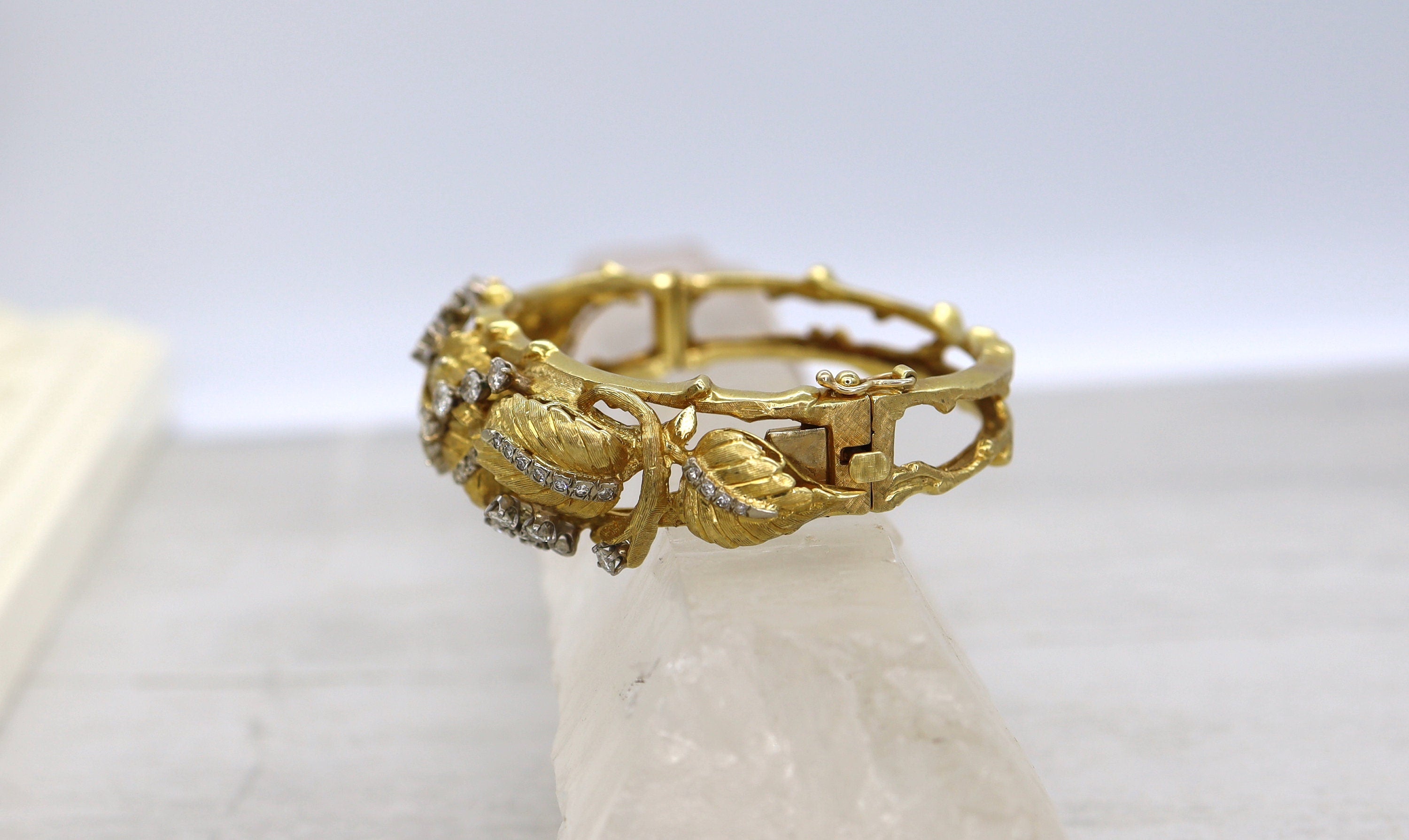 Vintage 1950s Jack Gutschneider 18k diamond bangle bracelet with intricate design and sparkling diamonds.