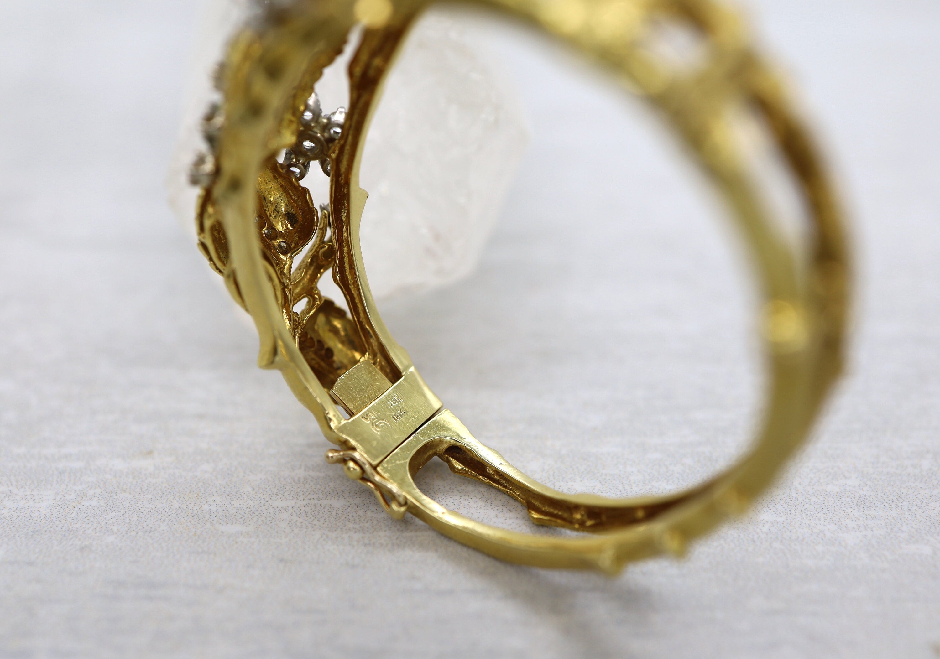 Vintage 1950s Jack Gutschneider 18k diamond bangle bracelet with intricate design and sparkling diamonds, crafted in gold.