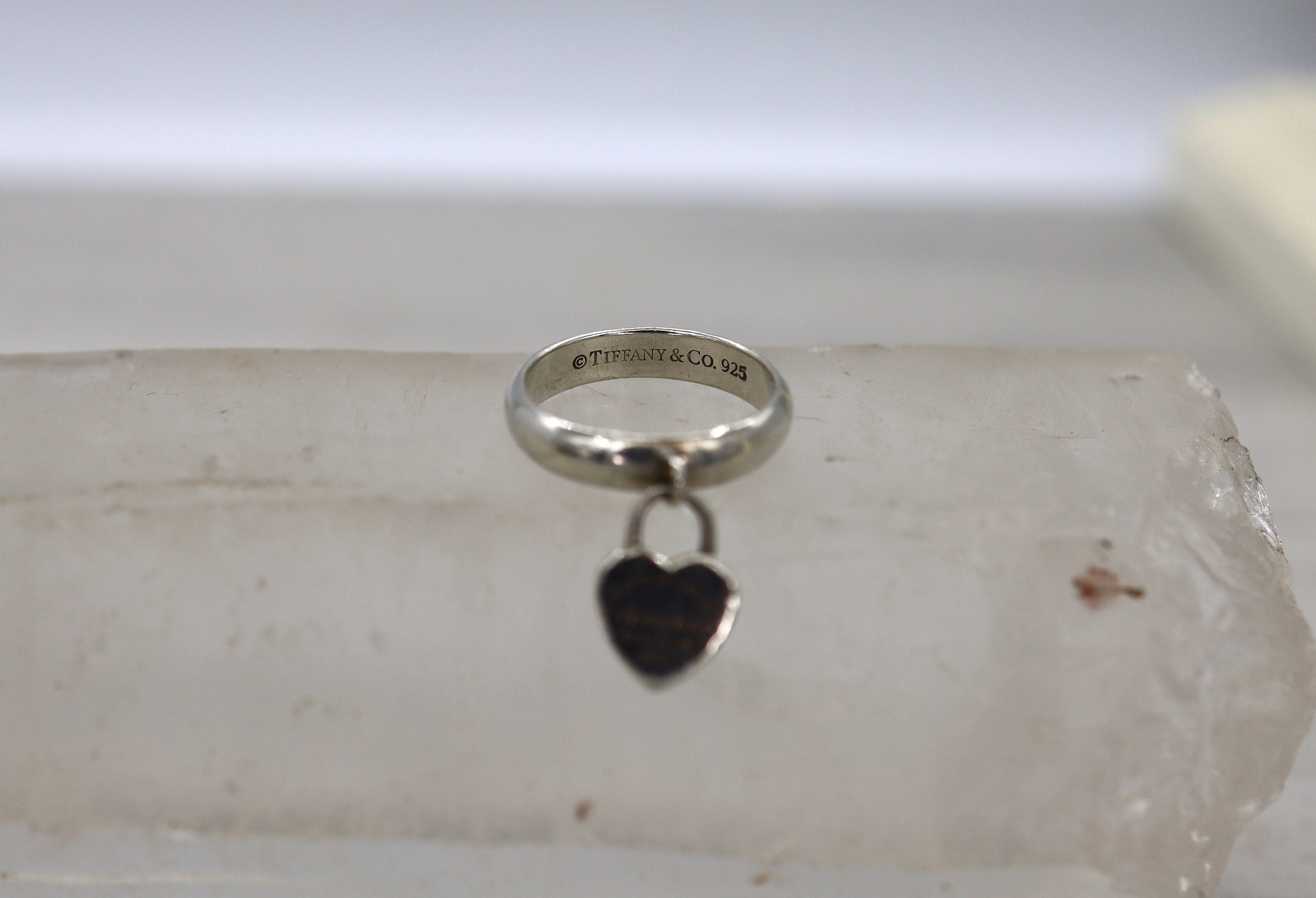Silver Tiffany & Co. Heart Charm Ring in size 5.5 with intricate heart design, showcasing a stylish jewelry piece.
