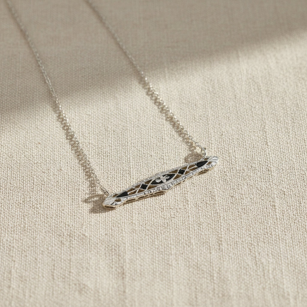 Art Deco bar necklace with black enamel in 14k white gold, elegant jewelry piece showcasing vintage design and craftsmanship.