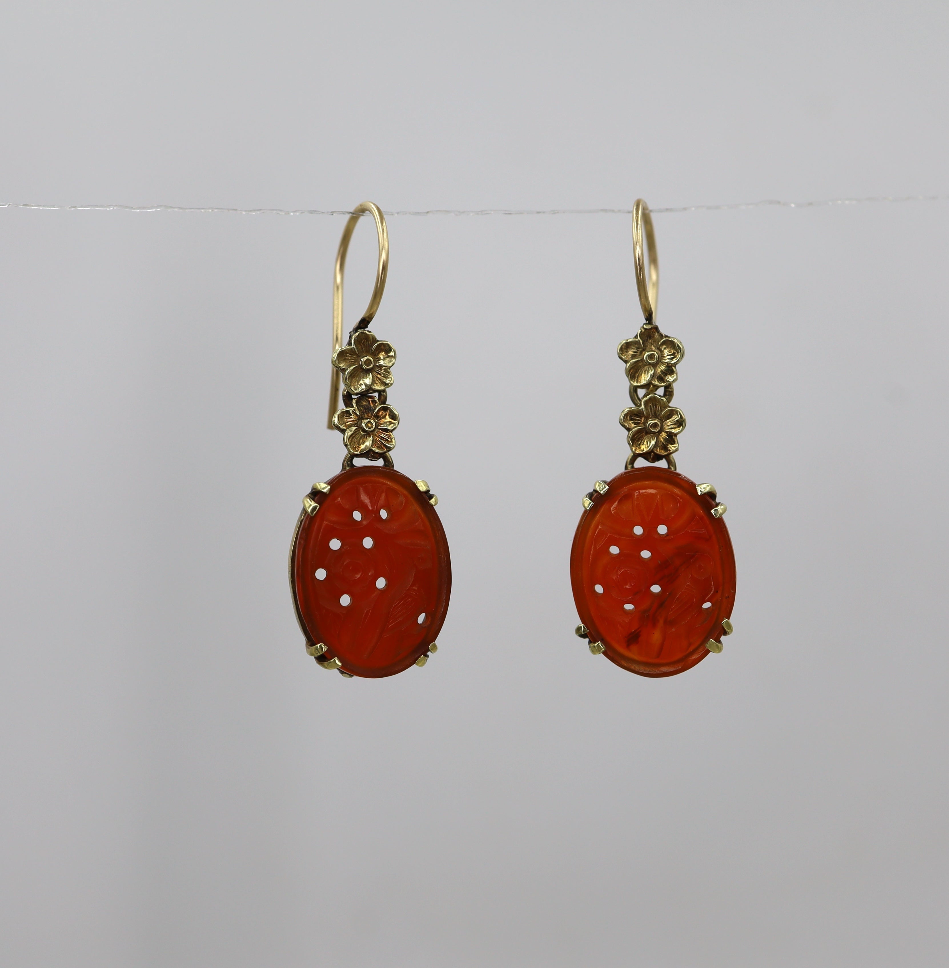Art Nouveau carved carnelian earrings in 14k yellow gold featuring intricate design and vintage craftsmanship.