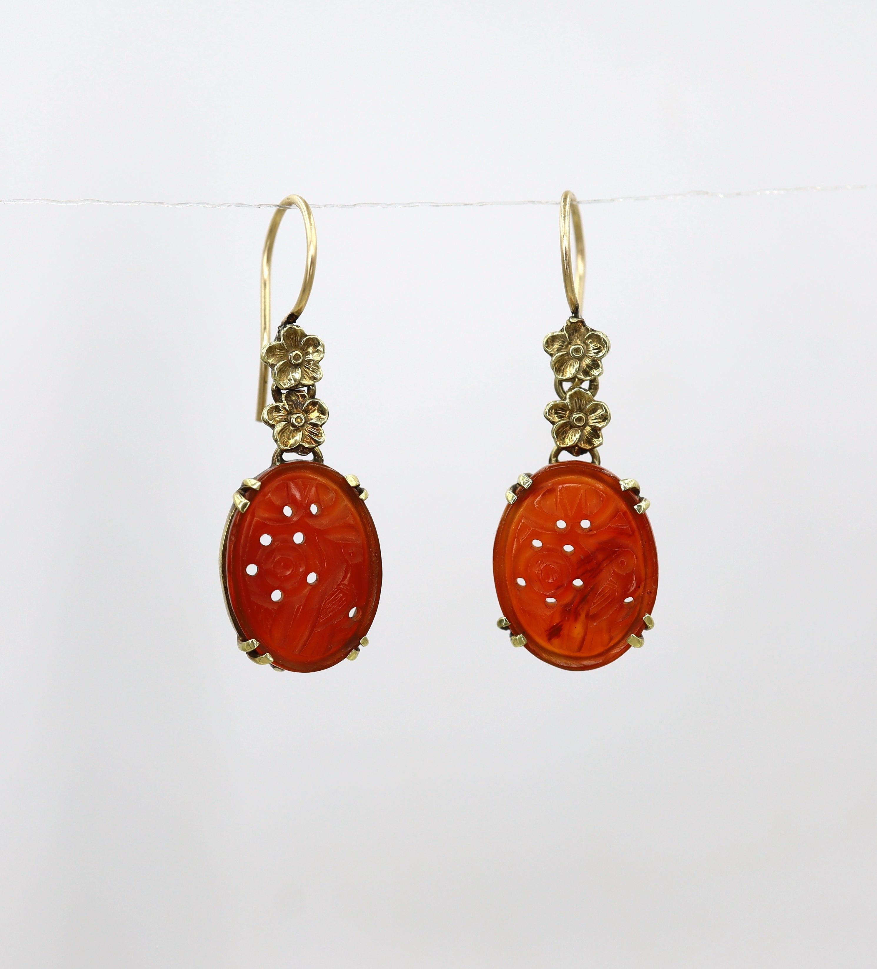 Art Nouveau carved carnelian earrings with 14k yellow gold settings, featuring intricate vintage design and detailed gemstone carvings.