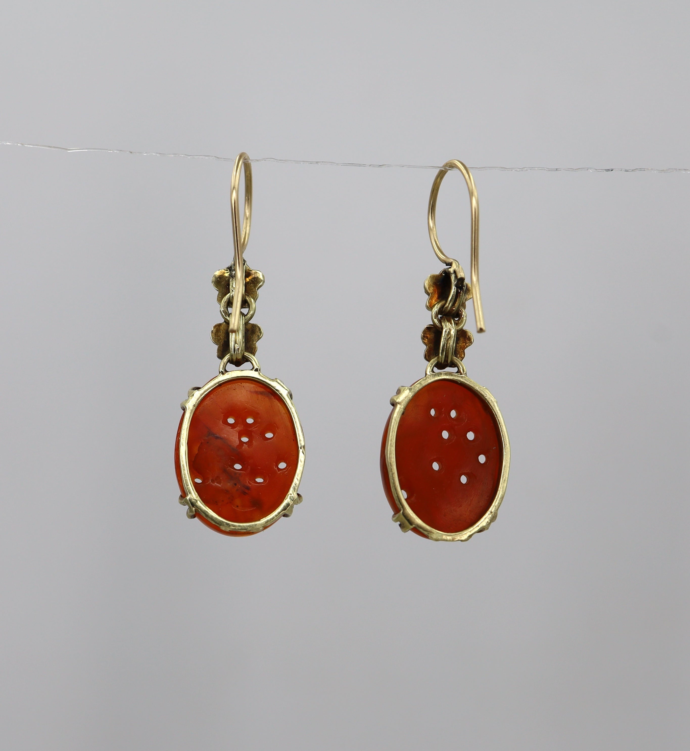Art Nouveau carved carnelian earrings with 14k yellow gold setting featuring intricate vintage design and detailed gemstone carvings.