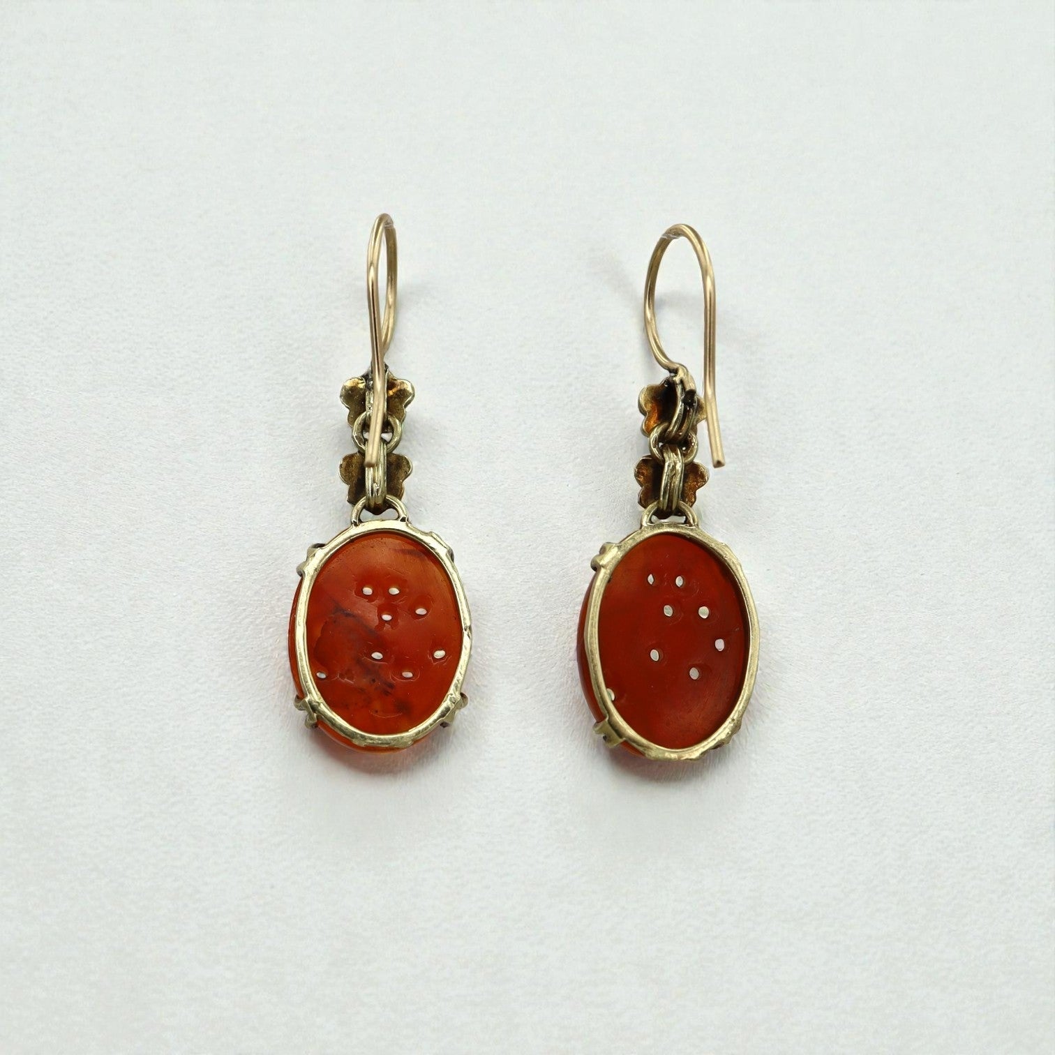 Art Nouveau carved carnelian earrings set in 14k yellow gold with intricate detailing, showcasing vintage craftsmanship.