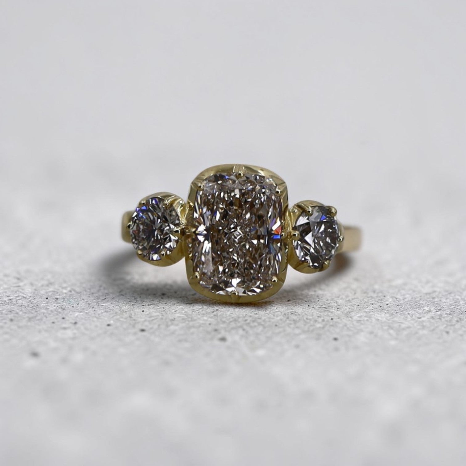 Petra Star Georgian-inspired three-stone engagement ring in 18k yellow gold with 4.24 cts of diamonds, showcasing intricate design and sparkle.