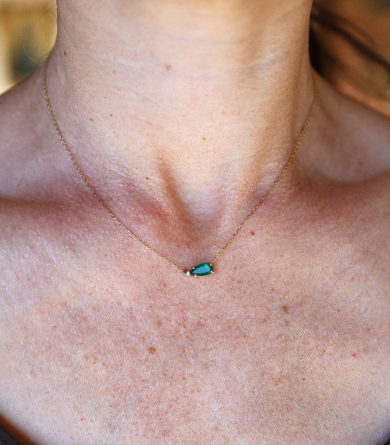 Petra Star emerald and diamond necklace worn by model, showcasing elegant jewelry with vibrant green emeralds and sparkling diamonds.