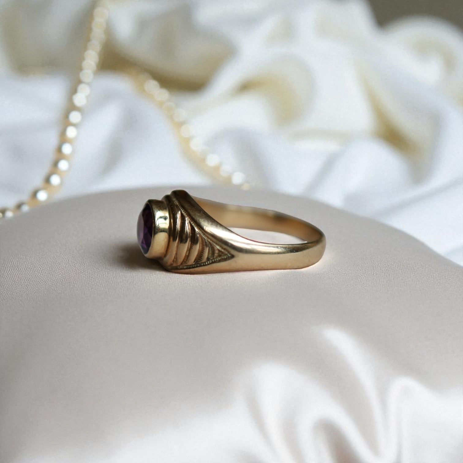 Vintage 1990s amethyst ring featuring a bezel-set purple gemstone on heavy 14k yellow gold tapered dome band.