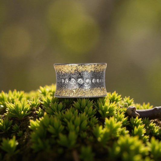 Silver ring with embedded stones on a bed of green moss