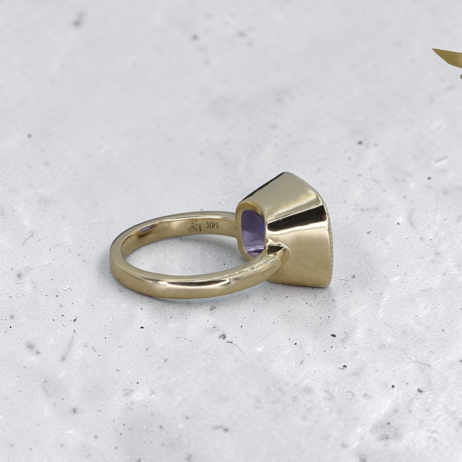 Cushion-cut tanzanite ring in 14k yellow gold with custom mount, featuring a sparkling central gemstone and elegant band.