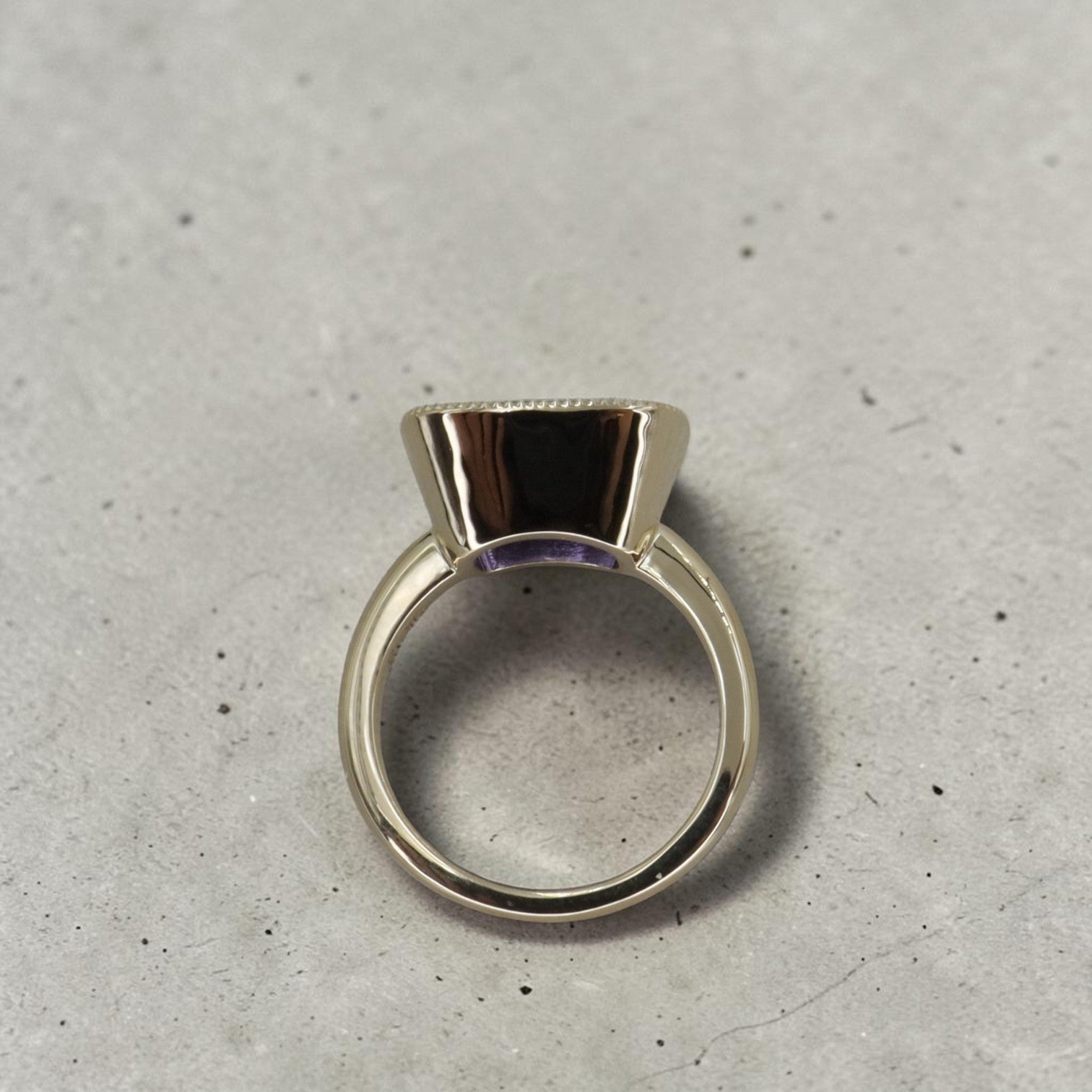 Cushion-cut tanzanite gemstone ring in 14k yellow gold, custom Petra Star jewelry setting, showcasing the elegant gemstone and gold band.