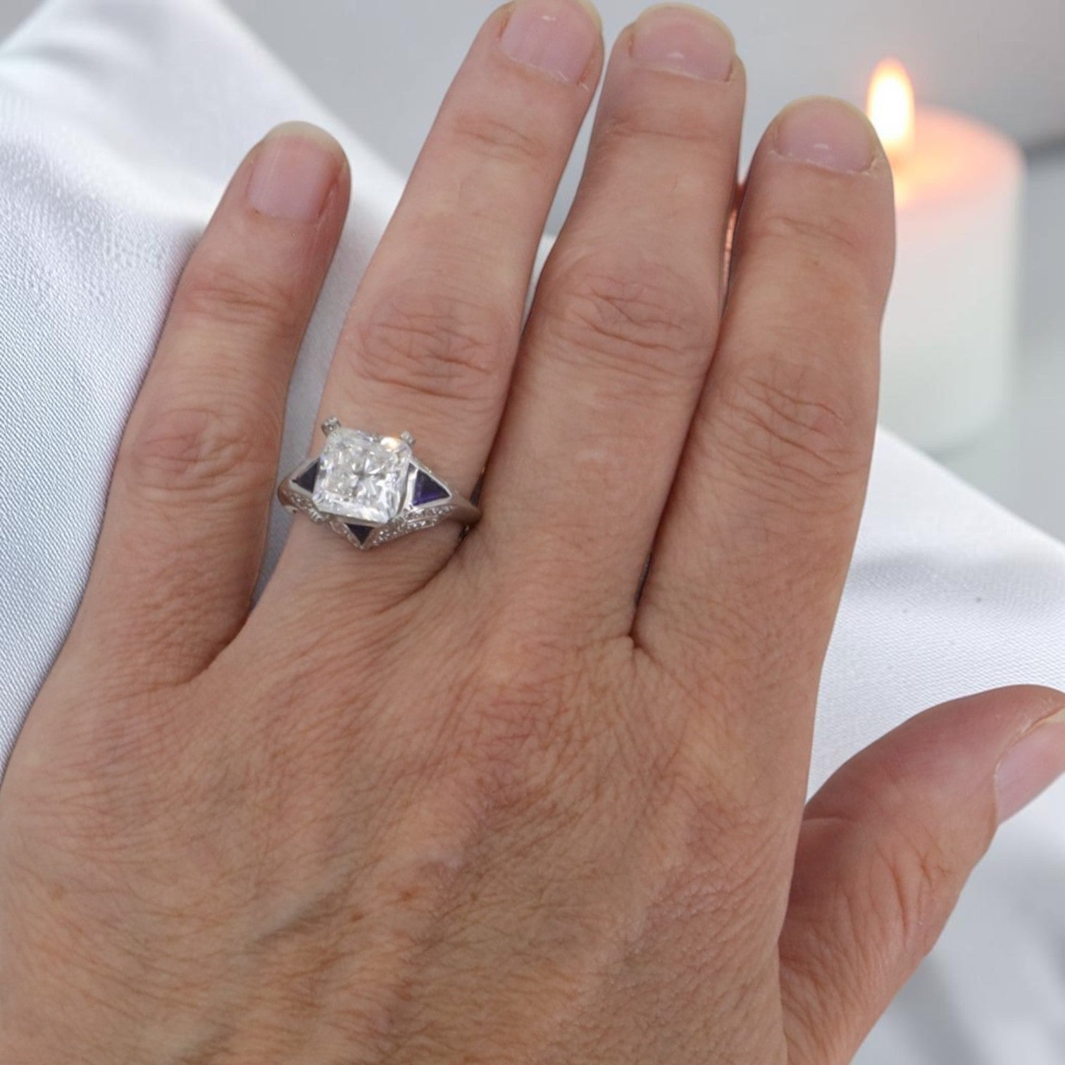 Art Deco platinum engagement ring with sapphire accents and a 3.09 ct lab-created radiant cut diamond, vintage-inspired design.