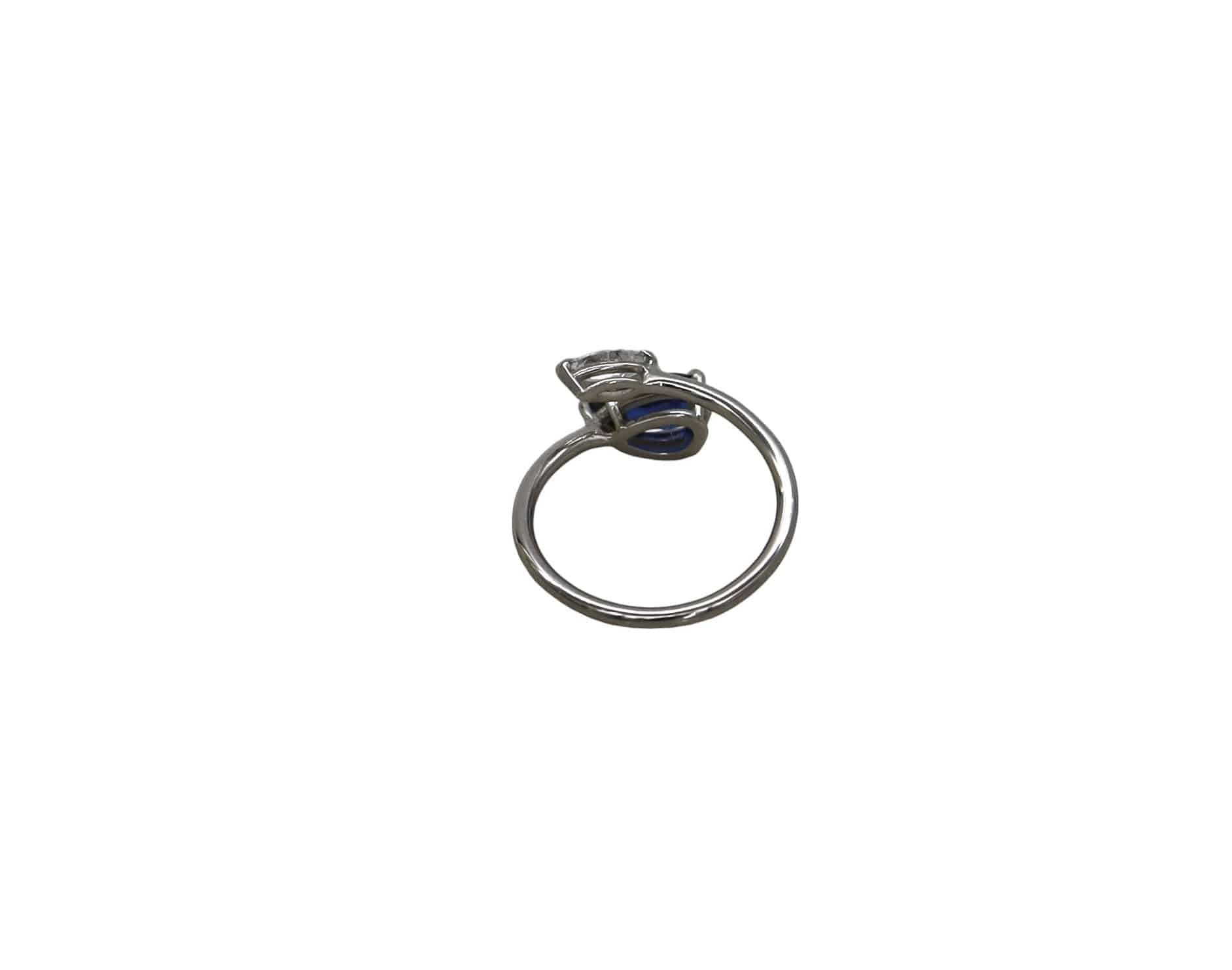 Petra Star sapphire bypass ring featuring a sleek silver band and a vibrant blue sapphire gemstone.