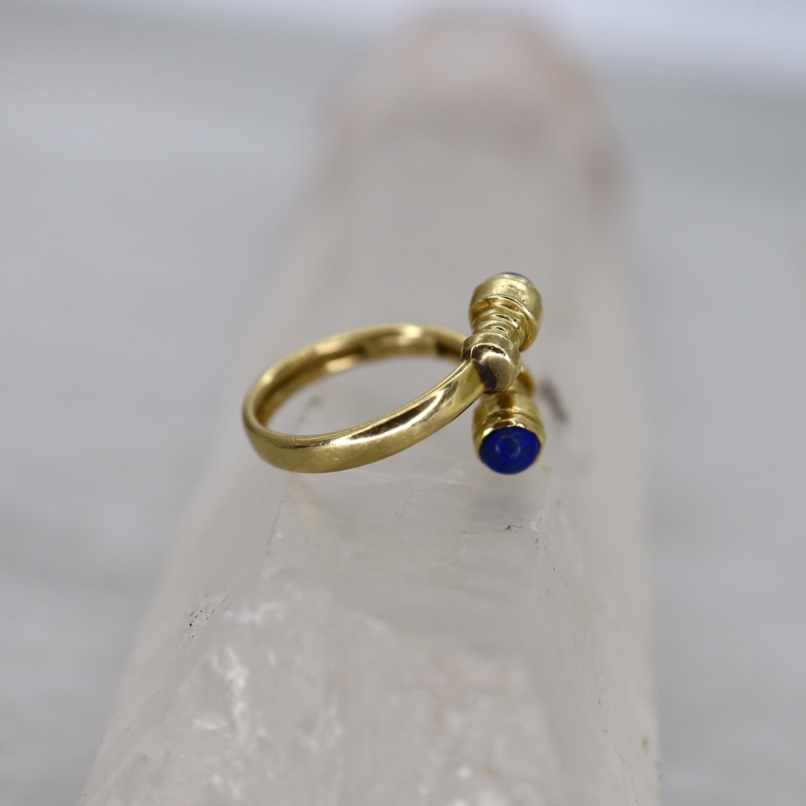 Vintage lapis bypass ring in 14k yellow gold featuring a sleek, modern design with vibrant blue lapis stones.