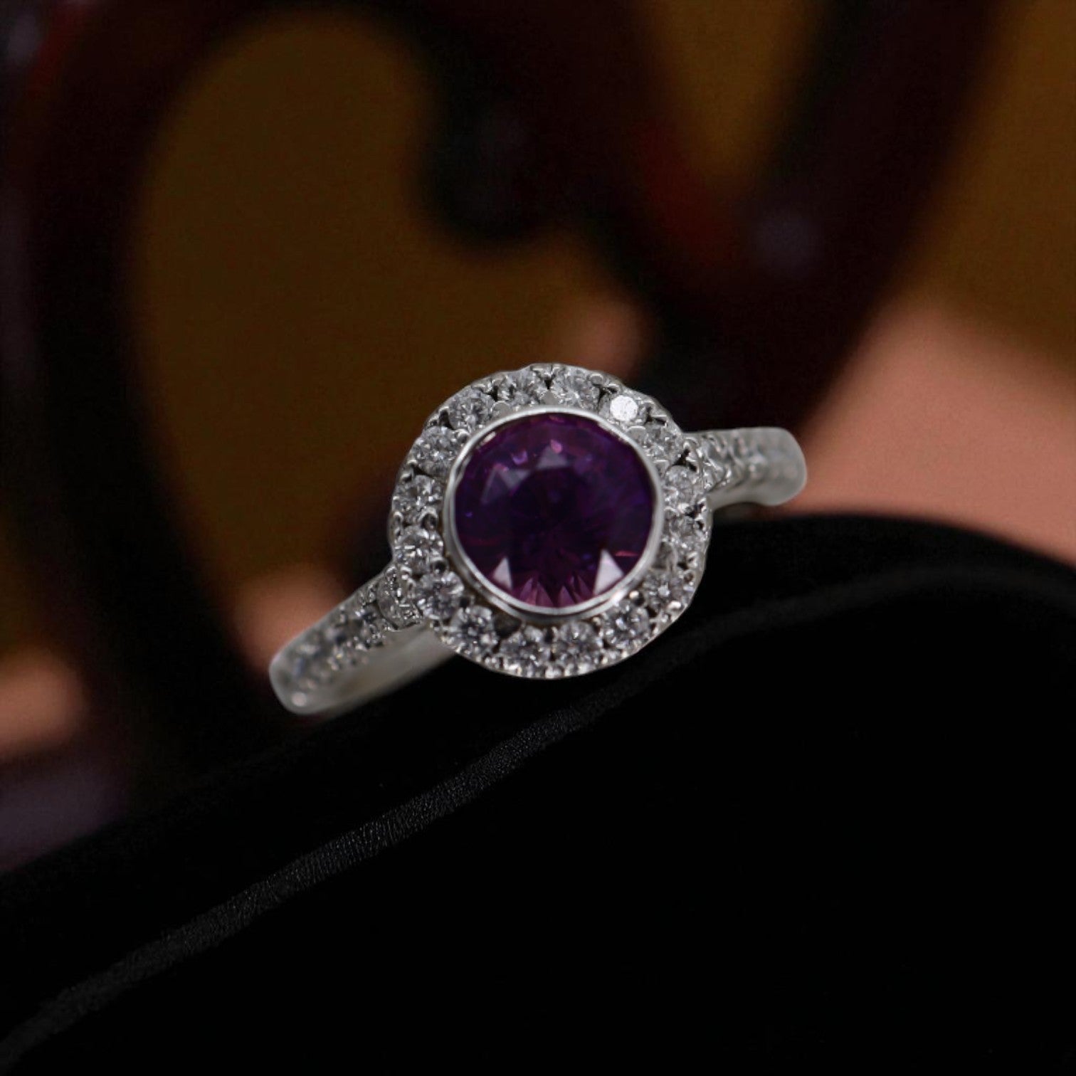 Purple sapphire halo engagement ring with diamond accents, featuring a vintage-inspired design on a silver band.