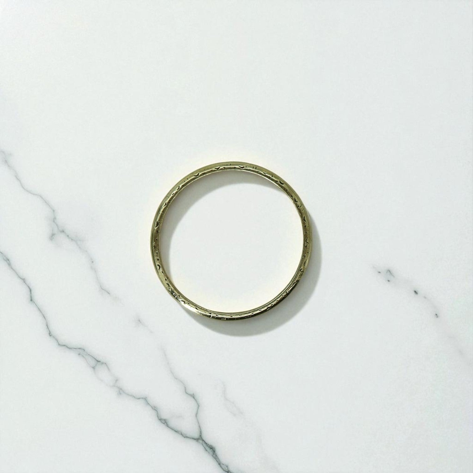 Antique 18k yellow gold band with faded engraved design, showcasing vintage craftsmanship and intricate details.