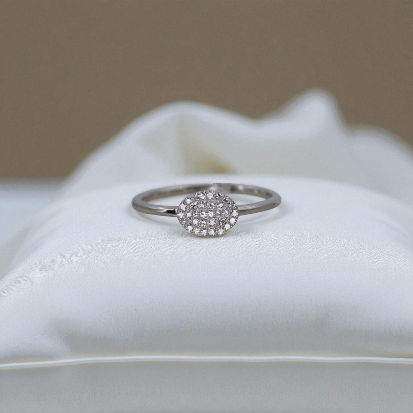 Silver ring with a diamond cluster on a white cushion
