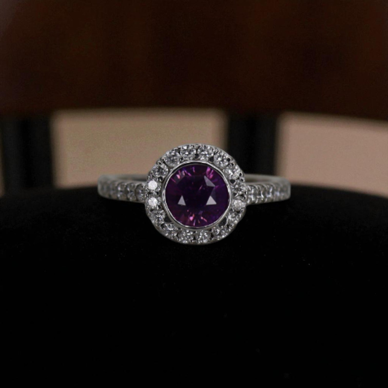Purple sapphire halo engagement ring featuring a central purple sapphire surrounded by a sparkling halo setting.