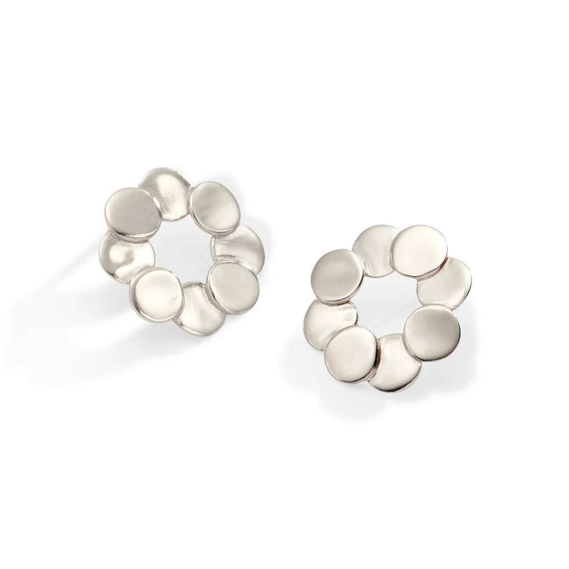 A pair of silver-toned stud earrings with a circular openwork design made of seven flat, overlapping disc-like elements, shown on a clean white background.