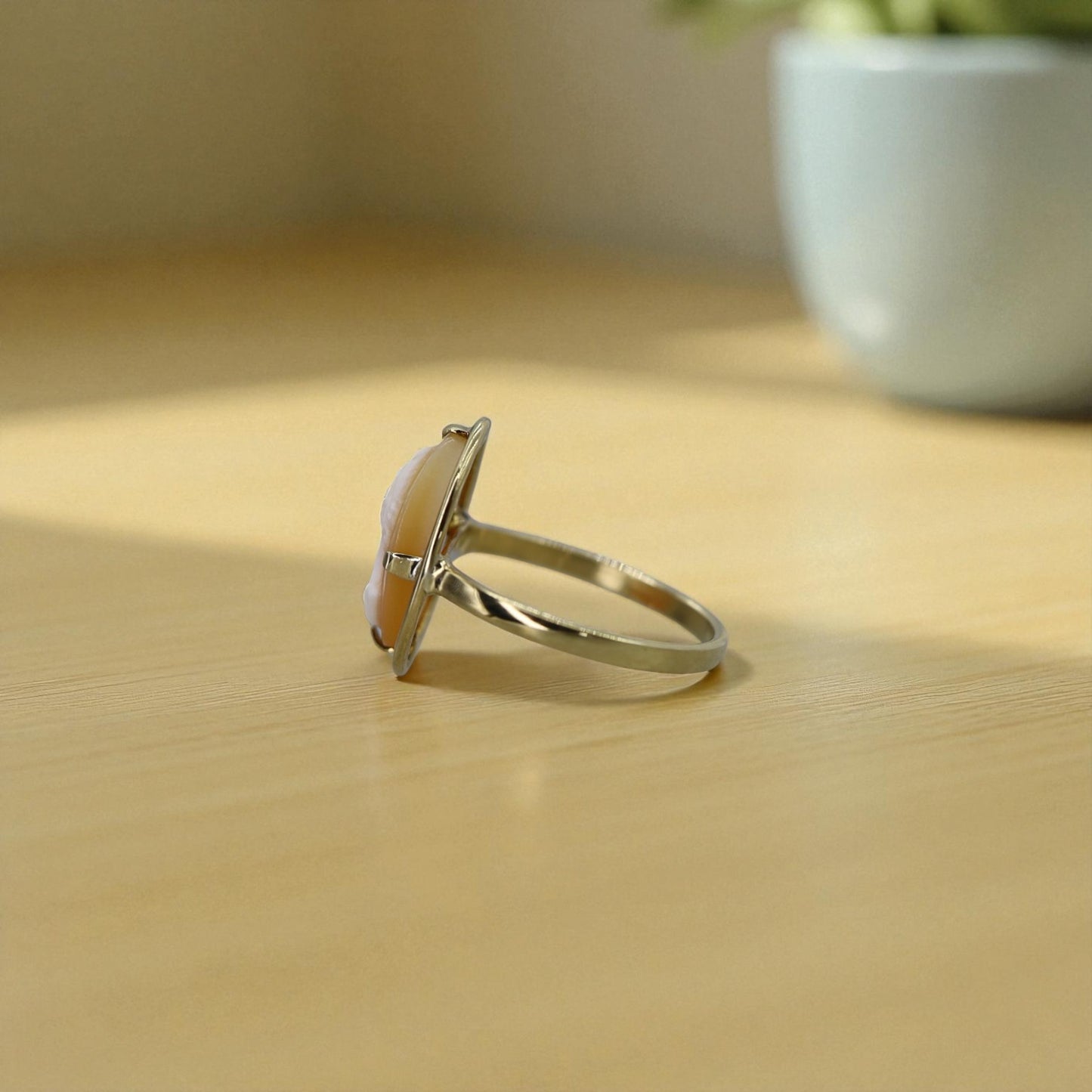 Silver ring with a large cameo on a wooden surface
