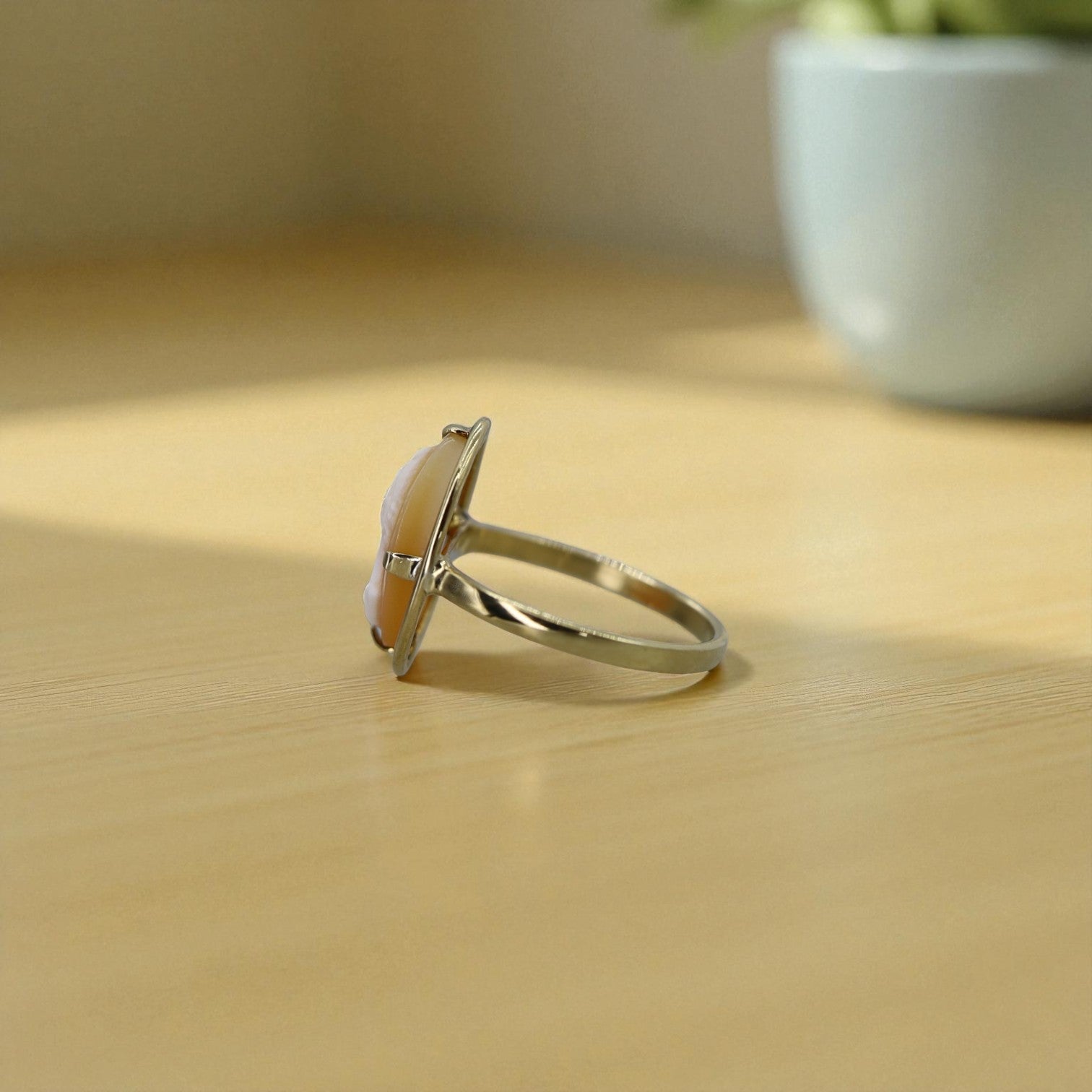 Silver ring with a large cameo on a wooden surface