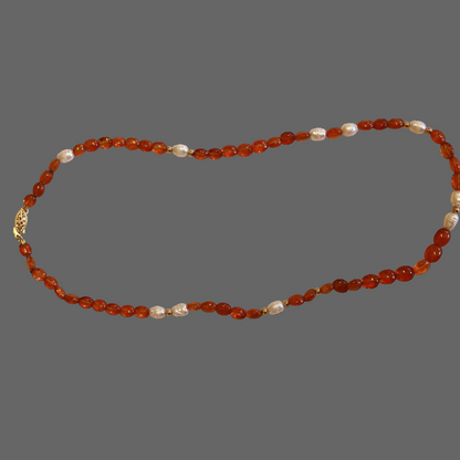 Necklace with orange beads and a gold clasp