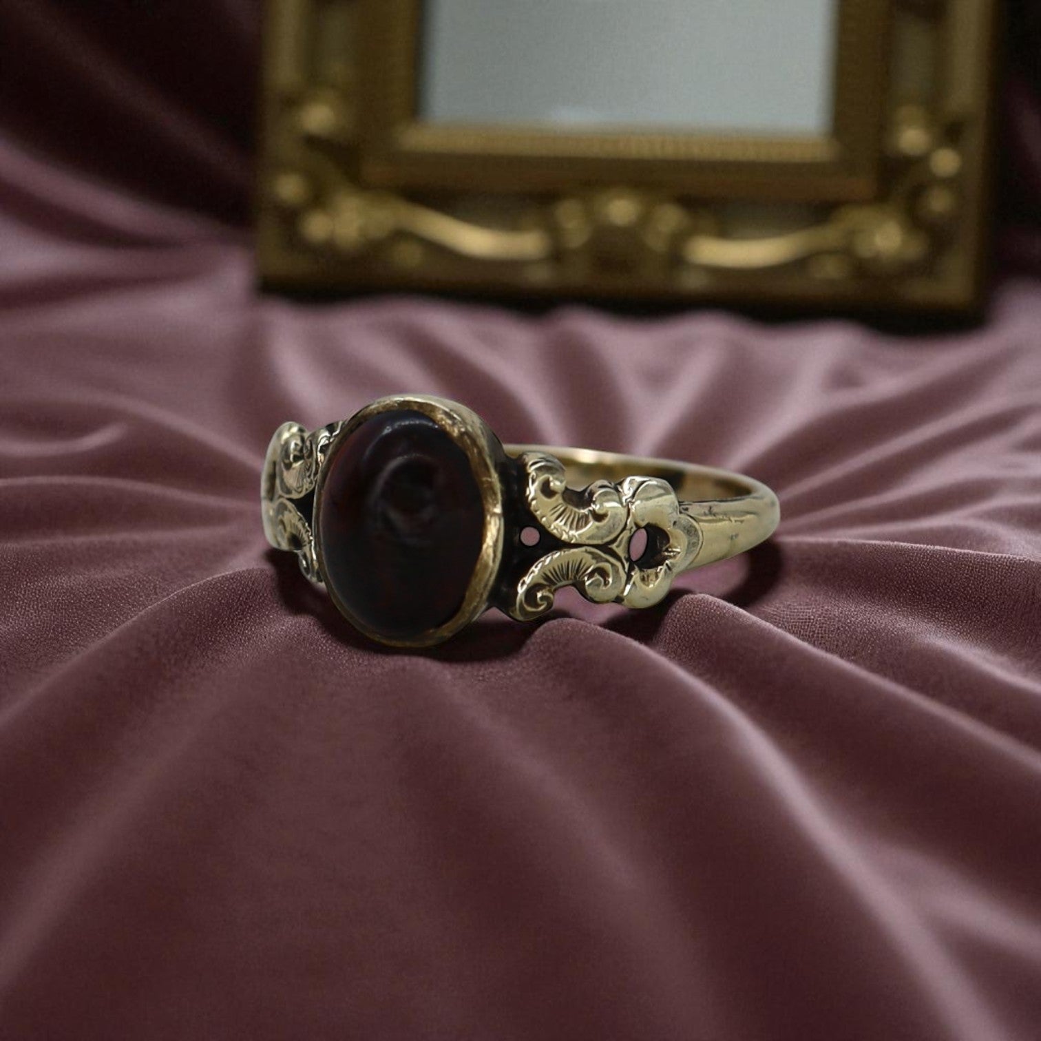 Victorian garnet ring featuring a deep red garnet gemstone set in an ornate vintage gold ring design.