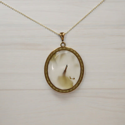 Victorian moss agate pendant with gold-filled setting, showcasing intricate vintage design and natural green and brown stone details.