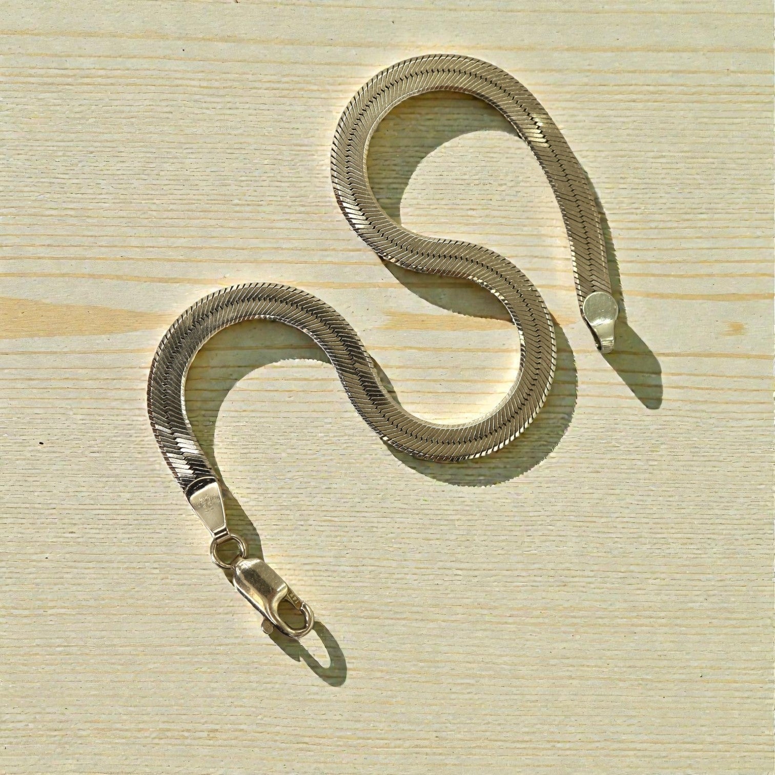 Vintage herringbone bracelet in 14k yellow gold, 4mm wide and 7 inches long, featuring a sleek, textured design.