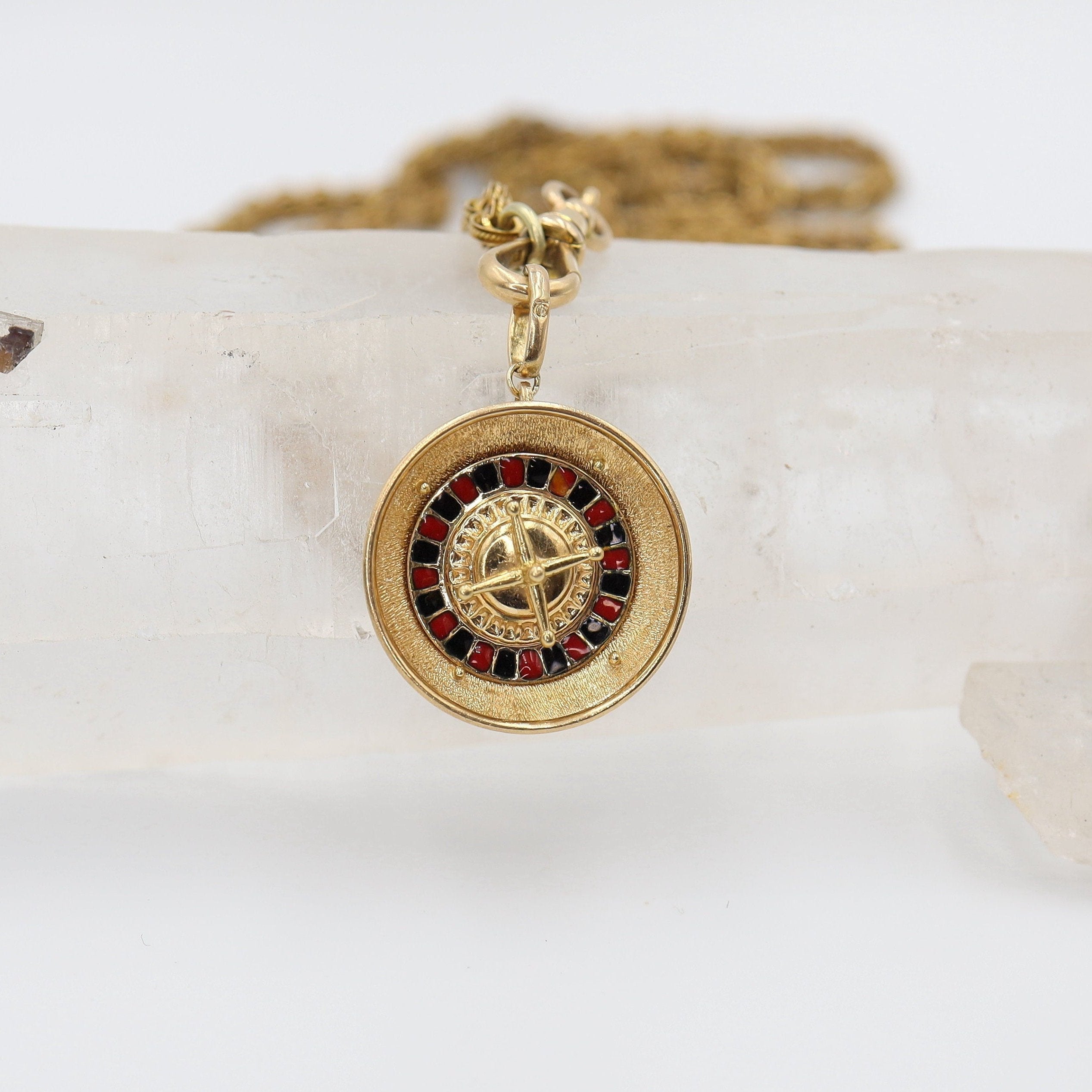 Vintage 18K gold moving roulette wheel pendant from The Vintage Vault, featuring intricate design and classic charm.