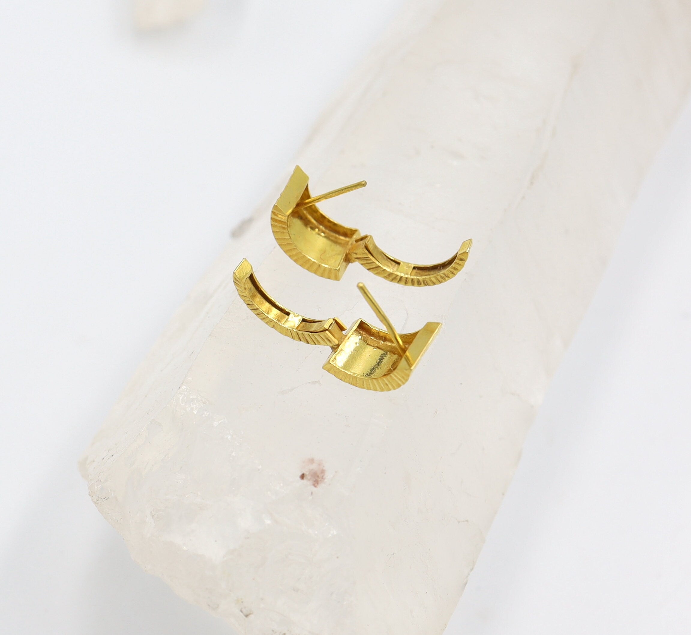 Vintage 22k gold huggie hoops earrings with a classic design, showcasing shiny, textured gold surfaces.