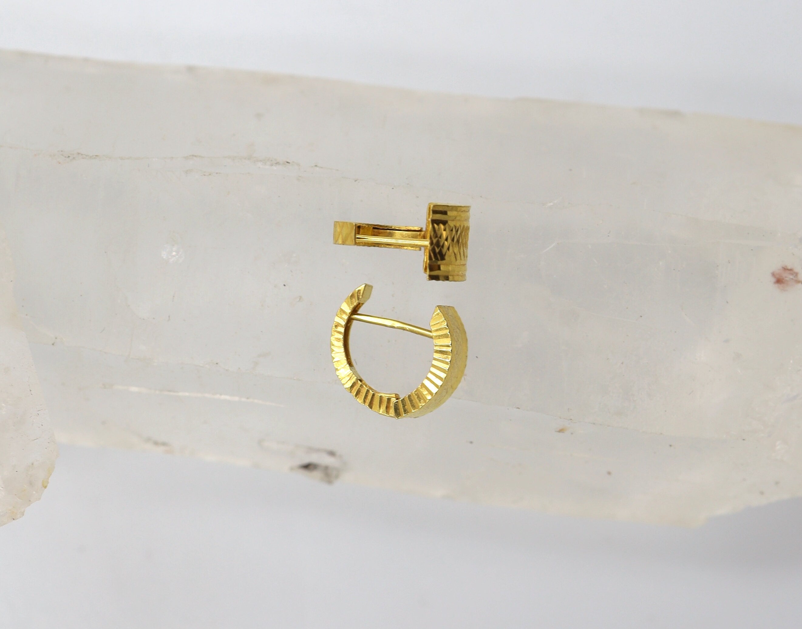 Vintage 22k gold huggie hoop earrings from The Vintage Vault, showcasing their classic round design and shiny finish.