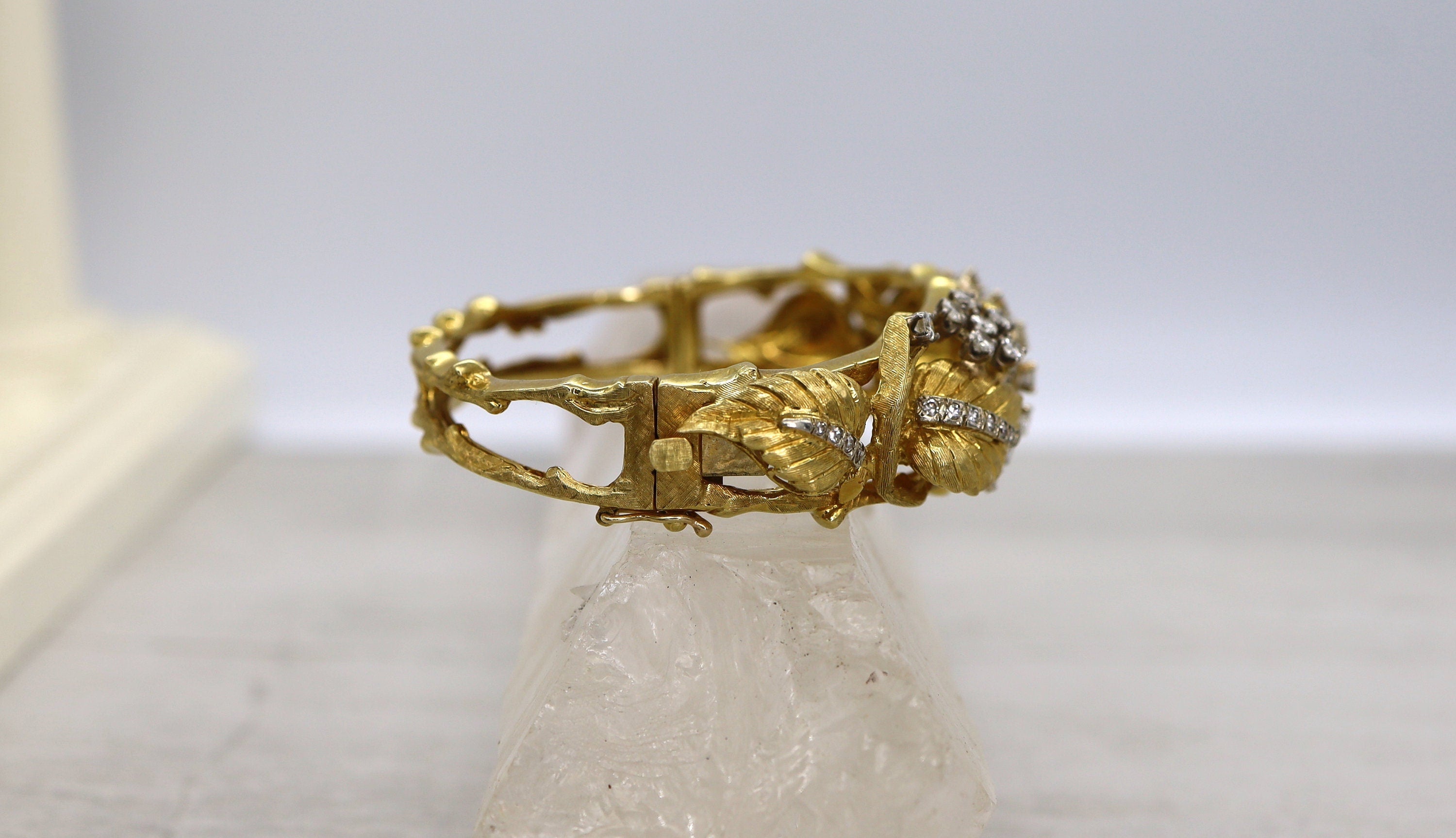 Vintage 1950s Jack Gutschneider 18k diamond bracelet showing intricate design and sparkling diamonds on a gold bangle.