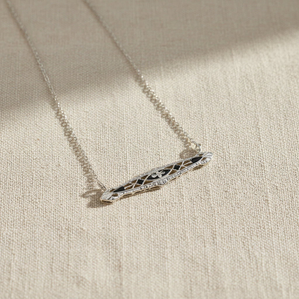 Art Deco  necklace with a decorative pendant on a beige fabric background