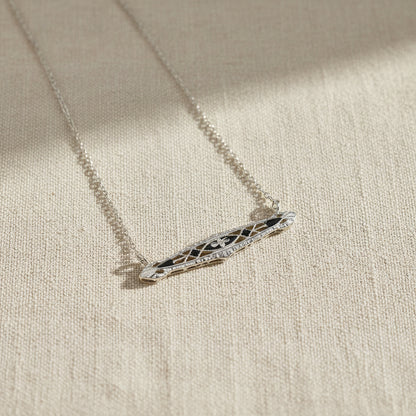 Art Deco  necklace with a decorative pendant on a beige fabric background