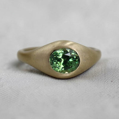 Petra Star Demantoid Garnet ring with antique-style satin finish in 14k yellow gold, showcasing a vibrant green gemstone.