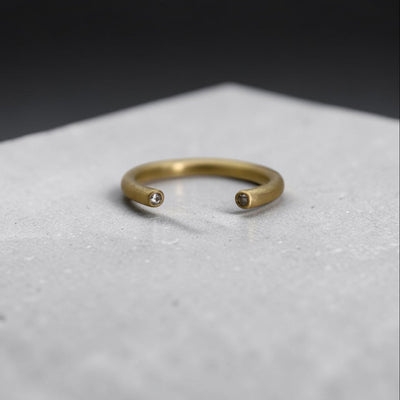 Close-up of Petra Star 18k gold open tube band with satin finish and diamond cap, showcasing modern minimalist jewelry design.